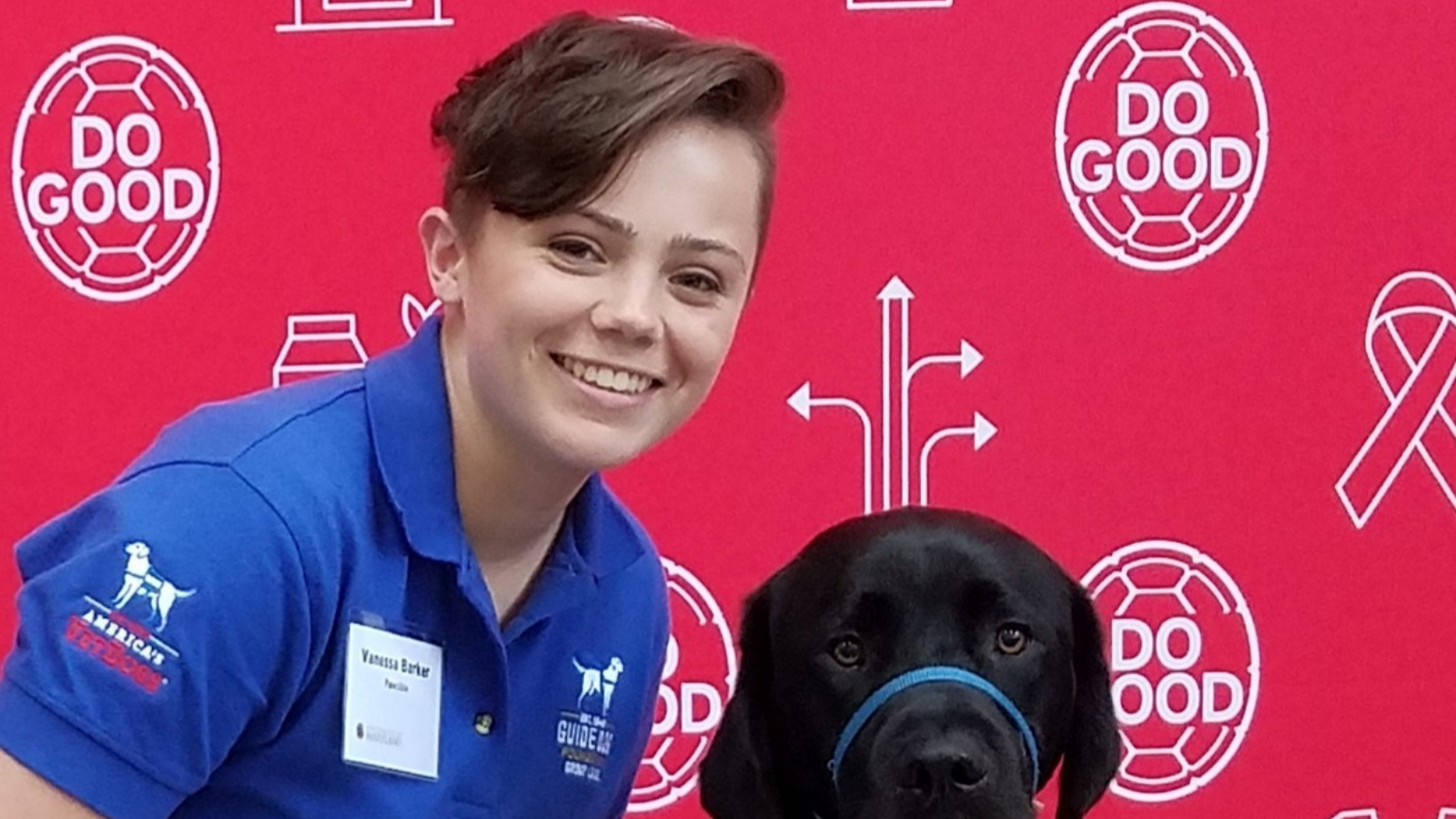 picture of college aged student, Vanessa, with a black dog. 