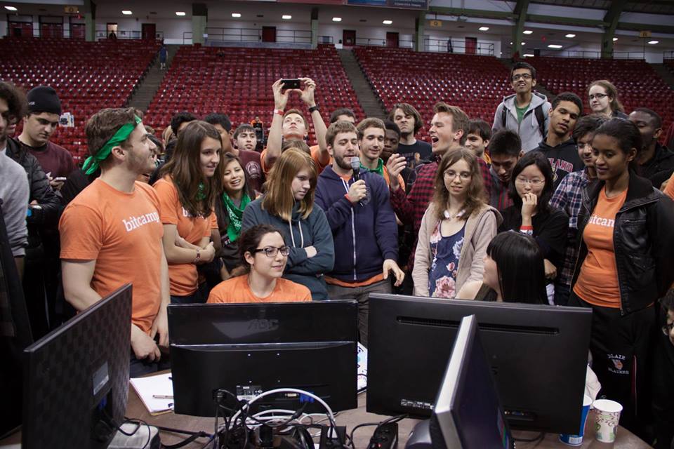 Students gather round a set of computer monitors for Bitcamps annual hackathon