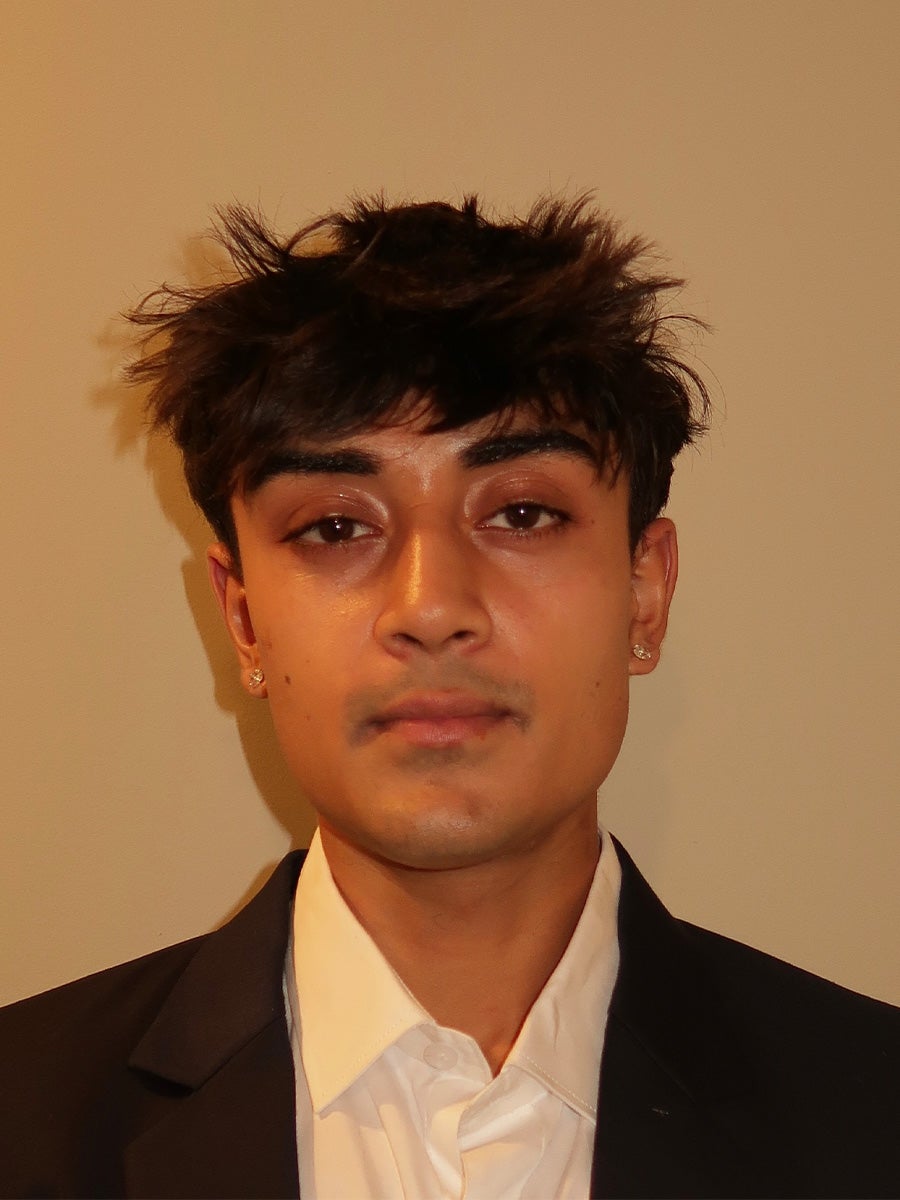 Katen's headshot is a guy with black hair and a black and white suit