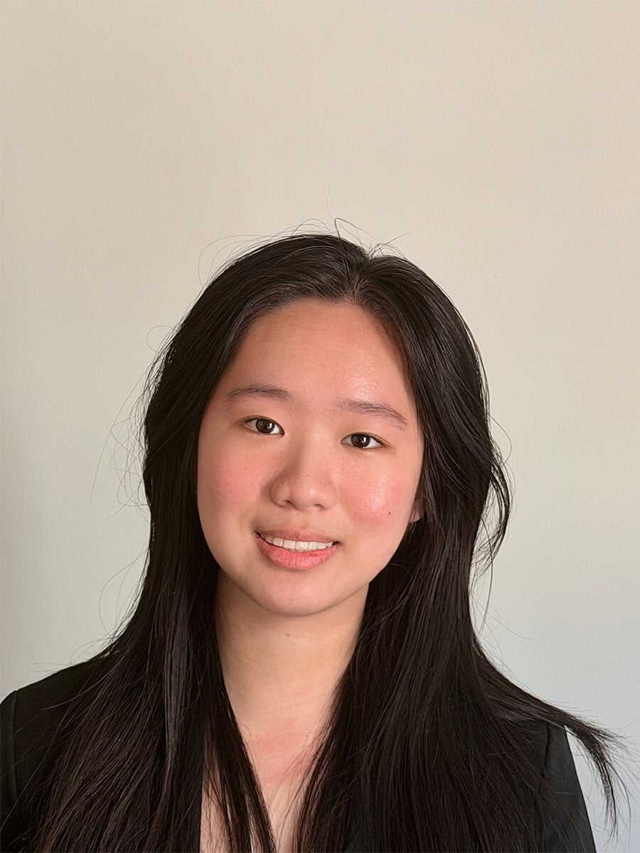 Cynthia Lin's headshot features an off white background and her wearing a black top