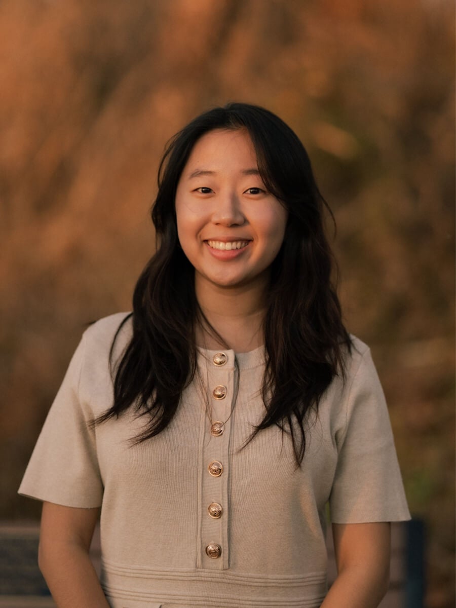 Joanna's headshot is of her smiling straight ahead with a beige shirt.