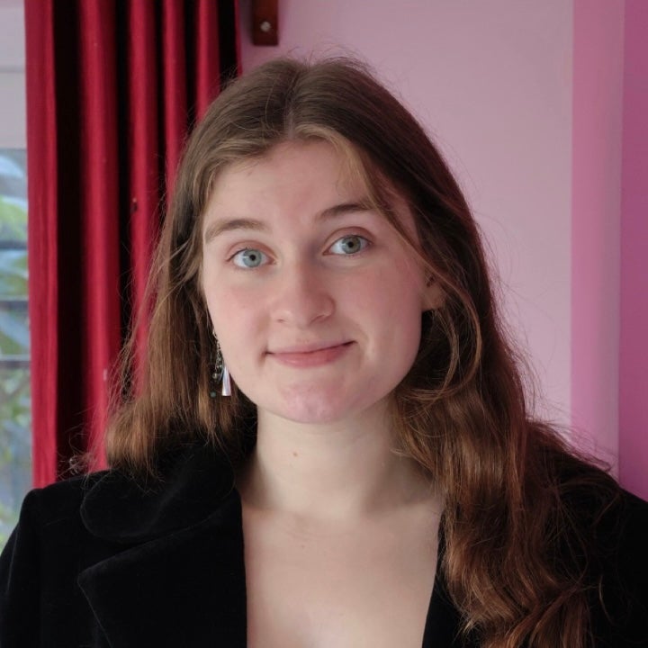 Julia's headshot features her smiling with a pink background.