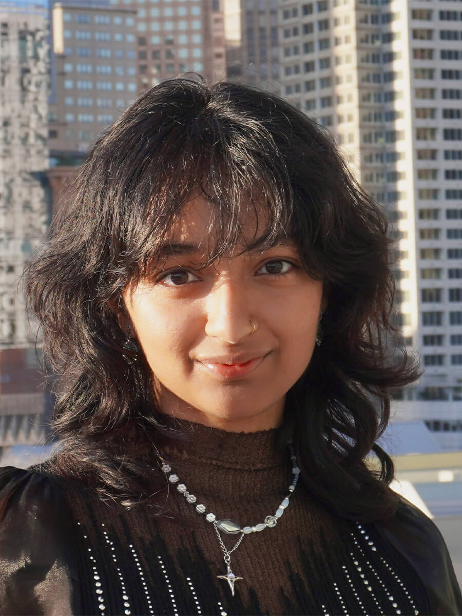 headshot of student wearing black shirt with a necklace