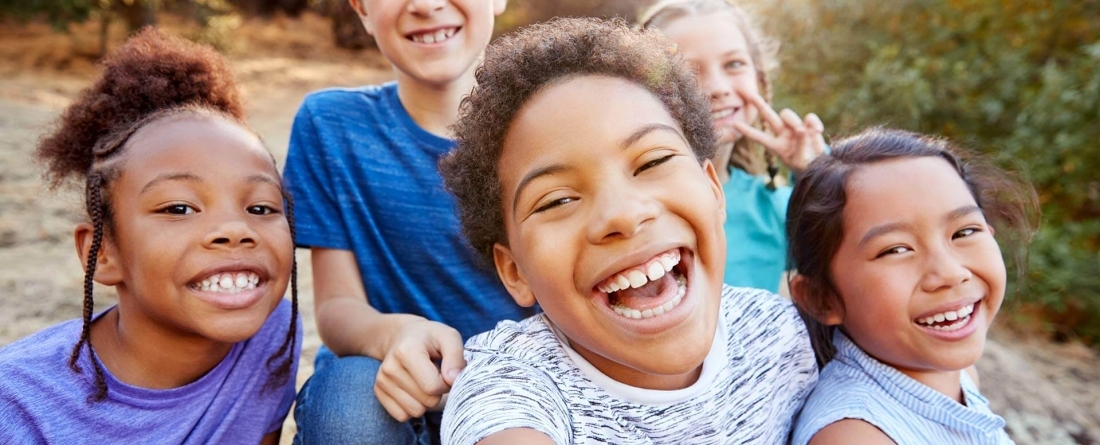 Four children playing and smiling