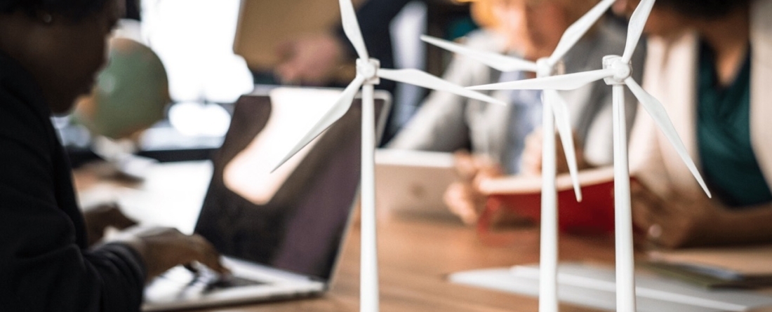 picture of wind mills on a desk with someone working on a computer behind it