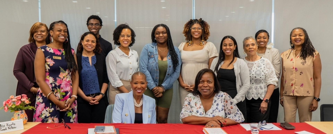 image of attendees gathered behind a table at book talk event