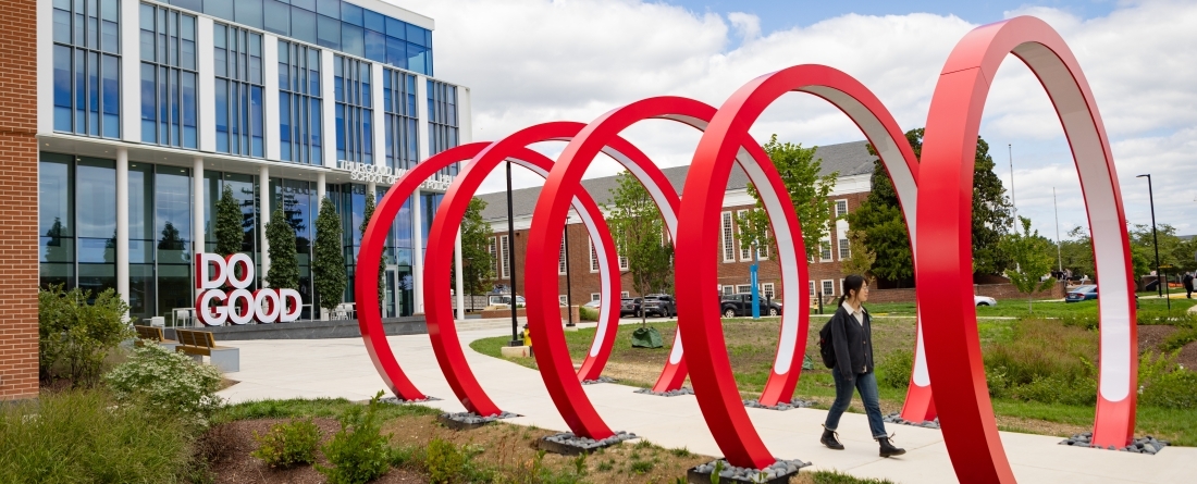 Student walking through tunnel of 5, 12" sculptural Rings