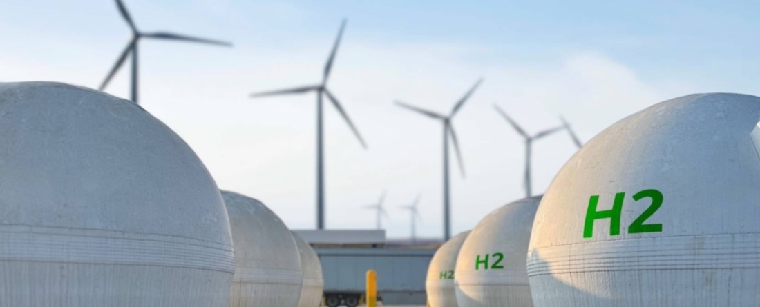 picture of hydrogen tanks with wind farm in the background