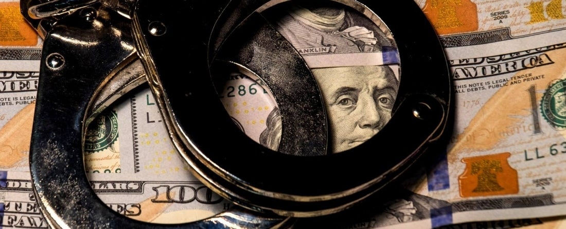 image of handcuffs on top of money