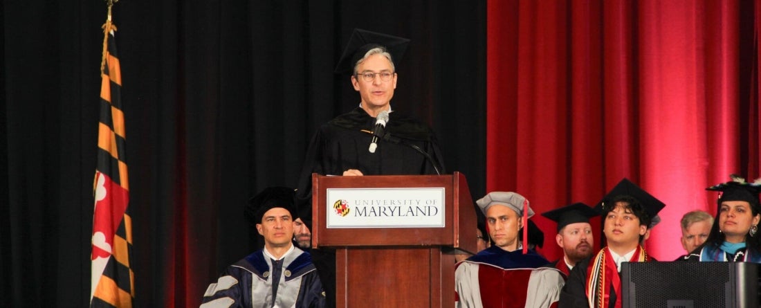 Damon Wilson standing at lectern giving commencement speech