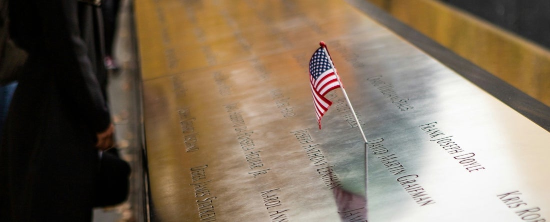 People standing at the 9/11 memorial in NYC
